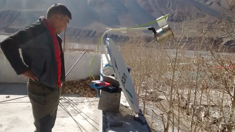 A Kaza resident looks upon the wi-fi link setup